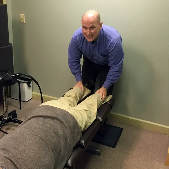 Dr. James Mattern adjusting a patient's legs