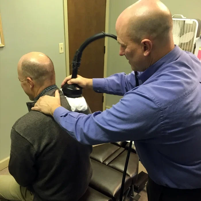 Dr. James Mattern using an instrument on a patient's shoulder